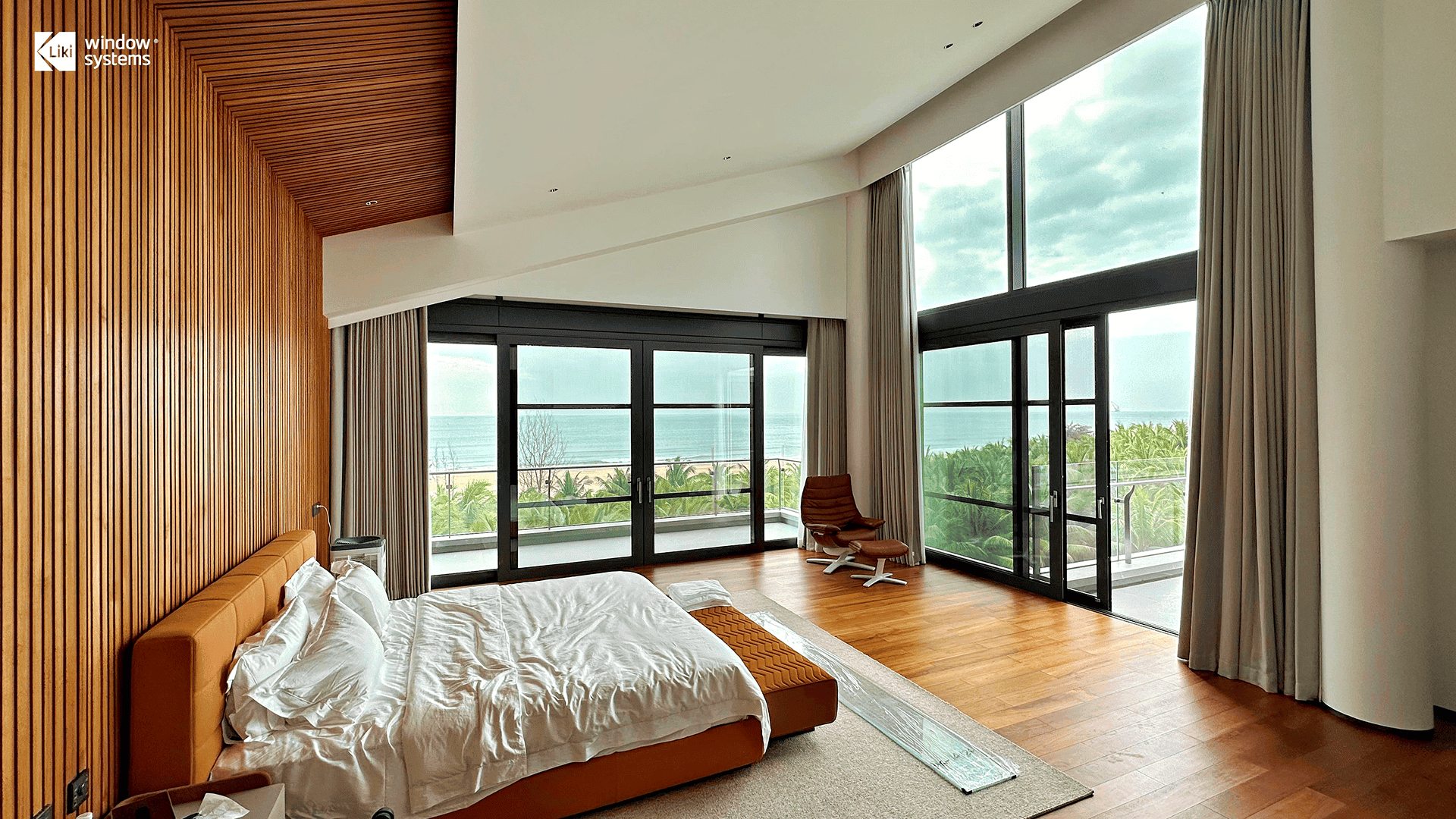 Modern coastal bedroom featuring LIKI slim frame aluminum sliding doors with panoramic ocean view, designed for tropical climates.