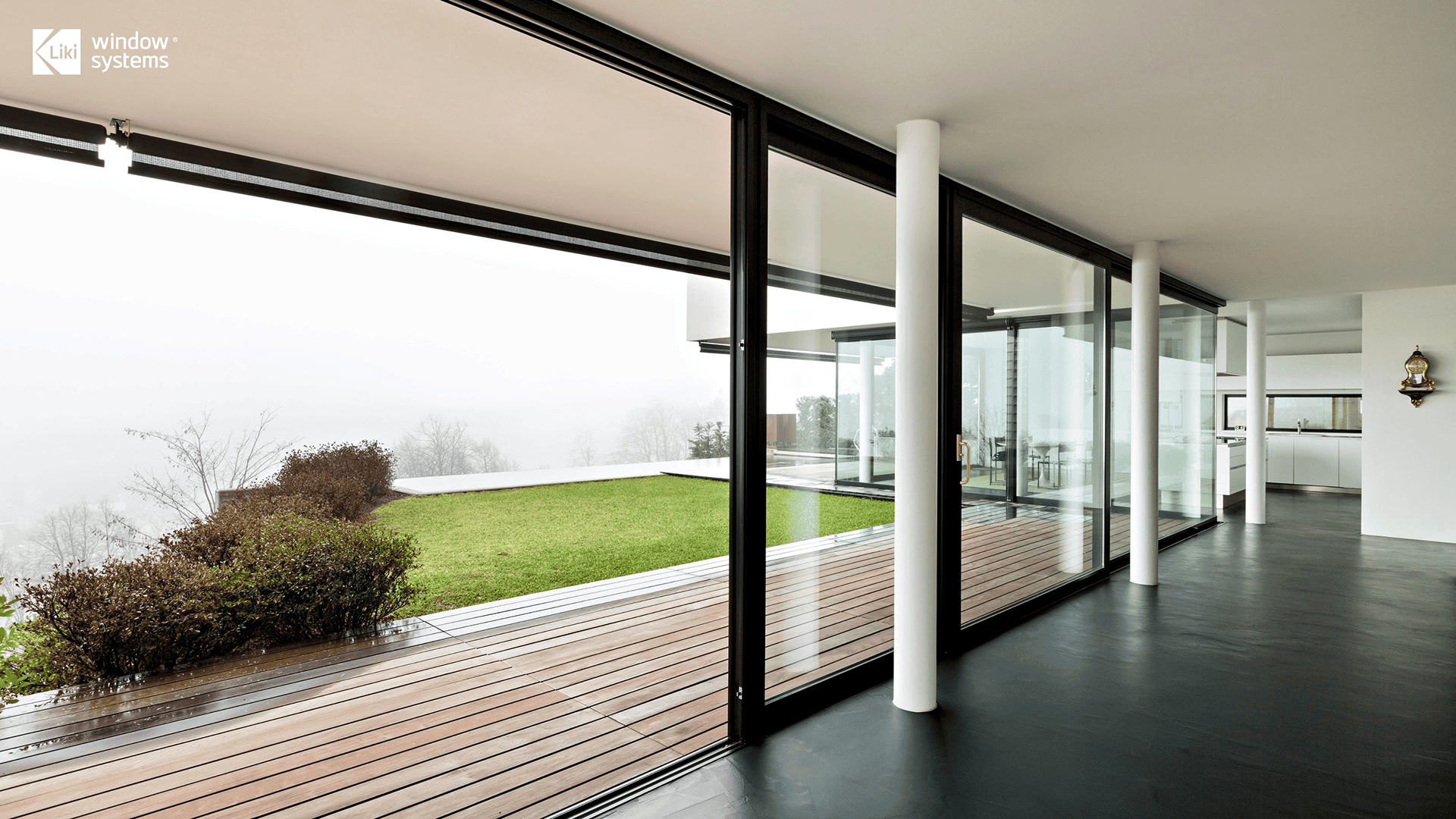 LIKI custom oversized aluminum lift and slide doors featuring slim black frames and floor-to-ceiling glass, creating a seamless indoor-outdoor connection for a modern luxury home.