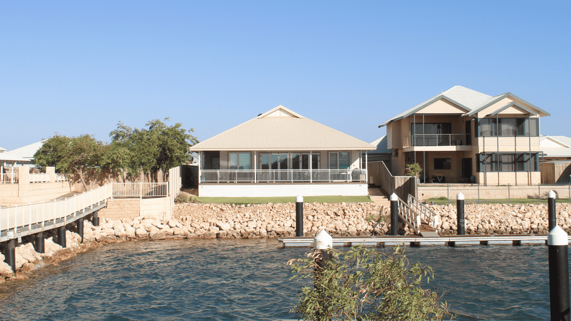 Rear facade of a modern Australian waterfront villa featuring Liki folding doors and 50 Series structural awning windows, designed to withstand high coastal winds.