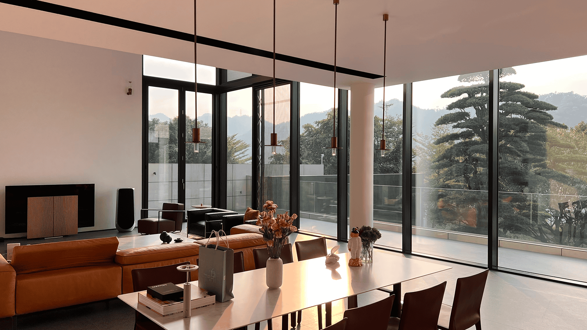 Detail shot of the dining area showcasing the minimal vertical sightlines of the LIKI glazing system. The flush-track design and narrow frames maximize natural light entry for a luxury dining experience.