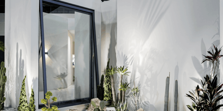Large custom aluminum awning windows integrated into a modern luxury home facade, demonstrating seamless sightlines and all-weather ventilation.